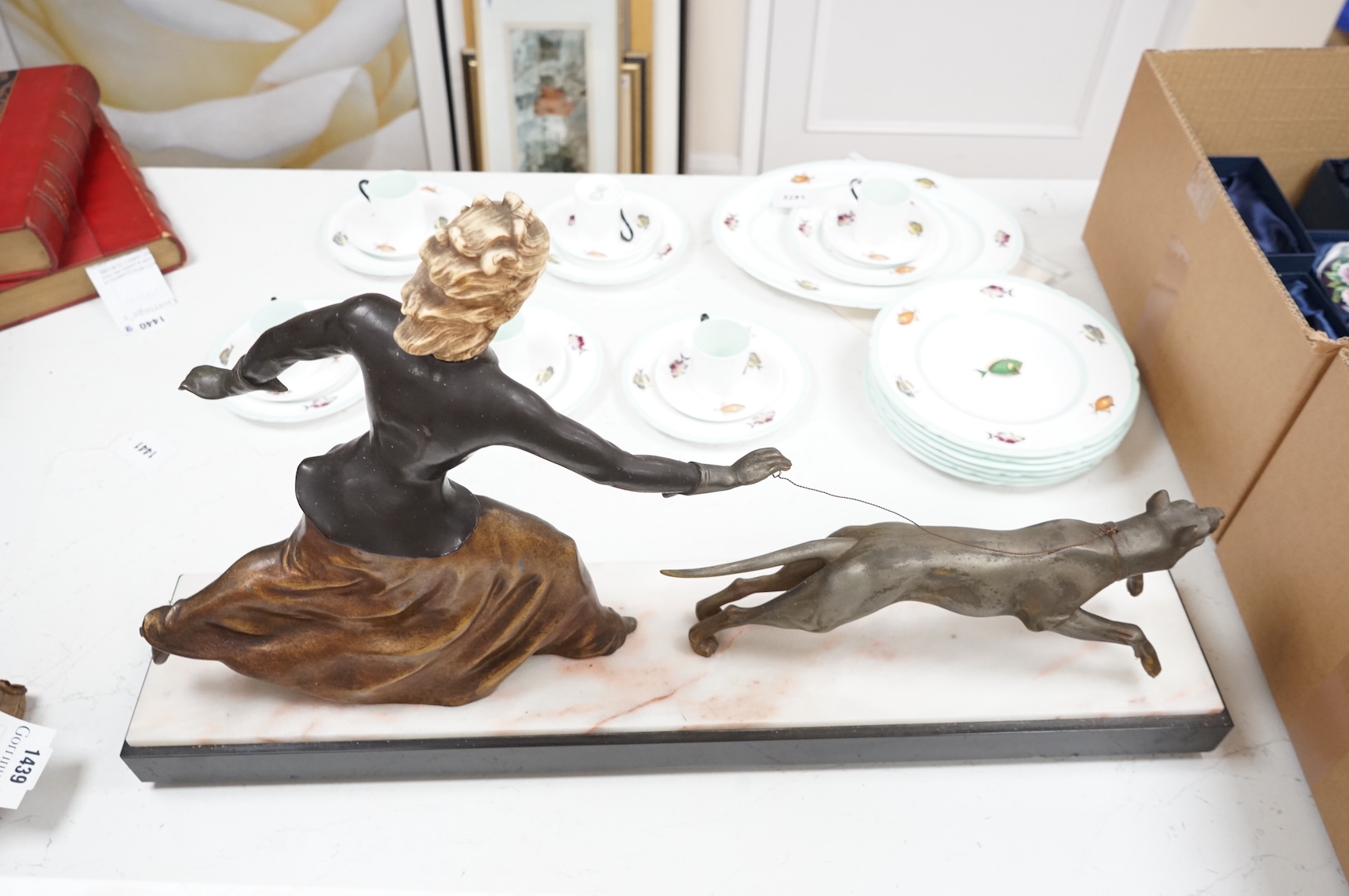 An Art Deco French spelter and ivorine model ‘Walkies Lady and Dog’, on a black marble and cream onyx base, 75cm long